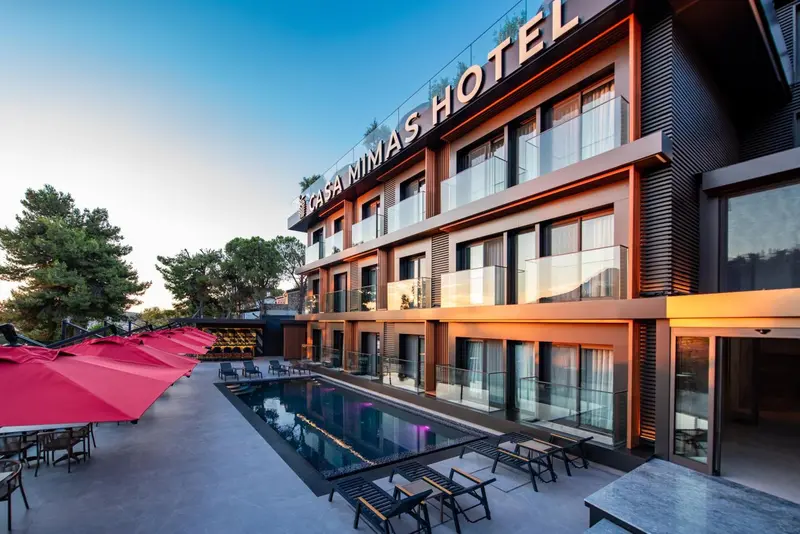 Façade d'un bâtiment moderne avec une piscine et des transats.