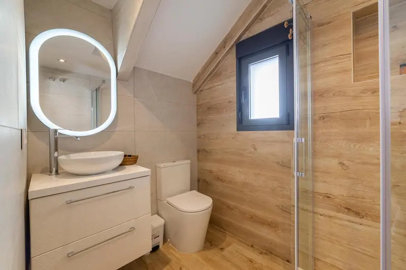 Une salle de bain moderne avec douche à l'italienne et vasque intégrée.