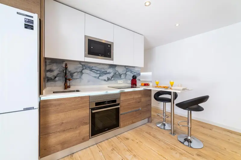Une cuisine moderne avec un plan de travail et des tabourets.