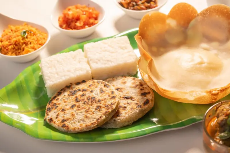 Assortiment de plats traditionnels servis sur une grande assiette verte.