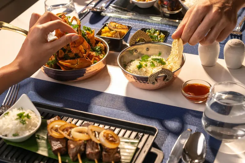 Une table est dressée avec des plats variés et des couverts.