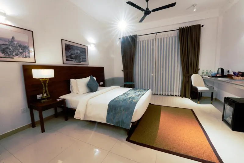 Une chambre lumineuse avec un lit double et un coin salon.