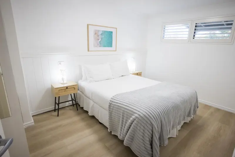 Une chambre lumineuse avec un lit double et une décoration sobre.
