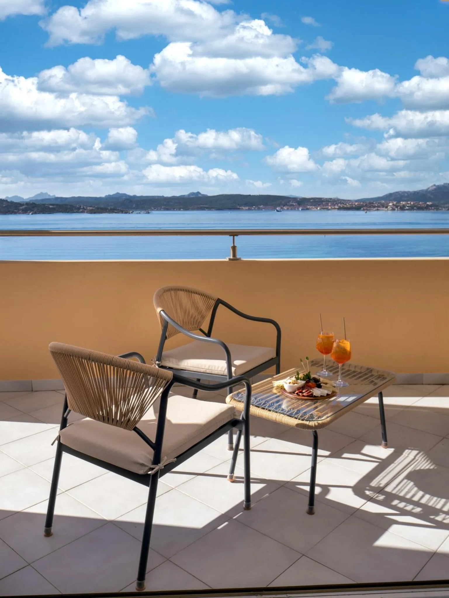 Terrasse avec mobilier et vue sur la mer.