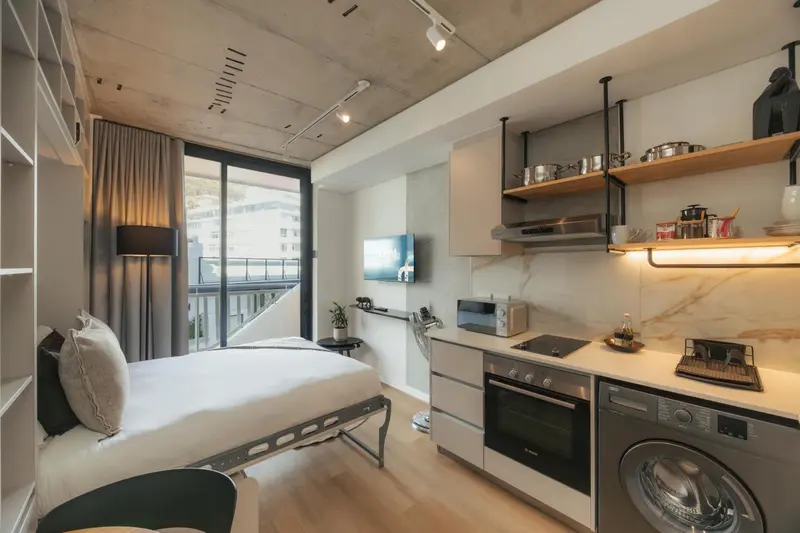 Une chambre moderne avec kitchenette et accès à un balcon.