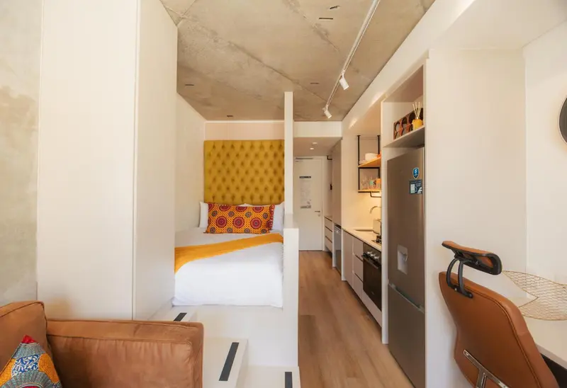 Une chambre moderne avec un lit et une kitchenette.