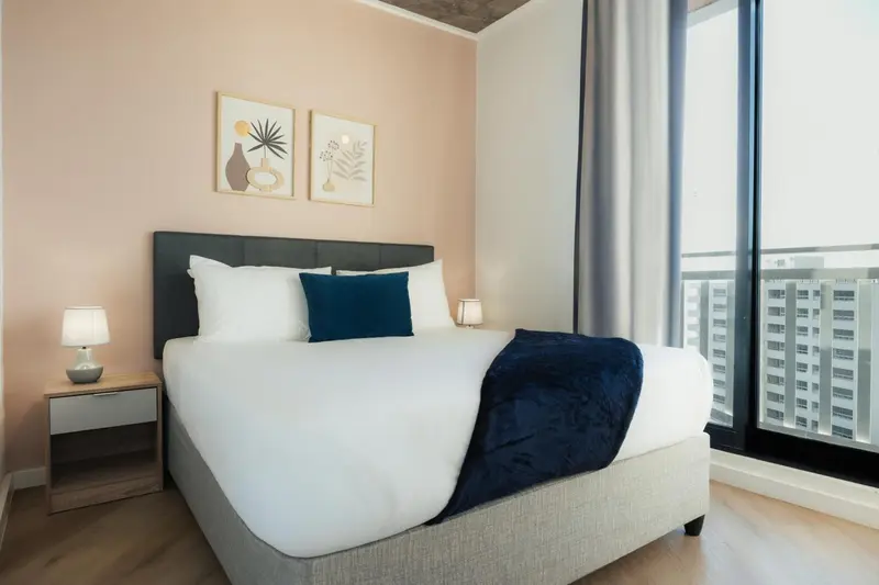 Une chambre lumineuse avec un grand lit et des tableaux décoratifs.