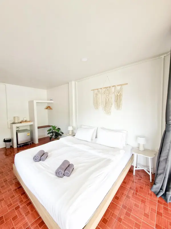Une chambre lumineuse avec un grand lit recouvert de draps blancs.