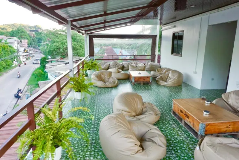 Espace de détente extérieur avec des fauteuils confortables et une vue sur la végétation.