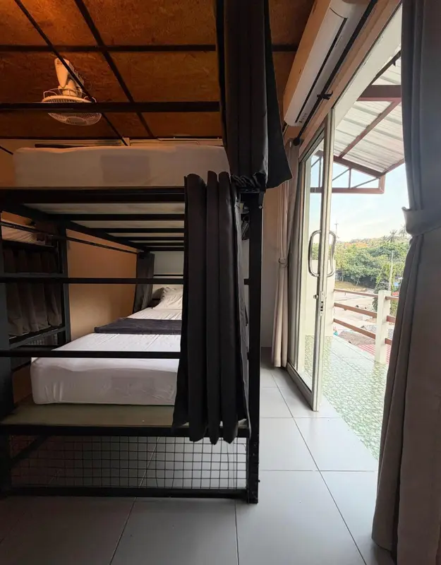 Chambre avec lits superposés et vue sur la végétation.