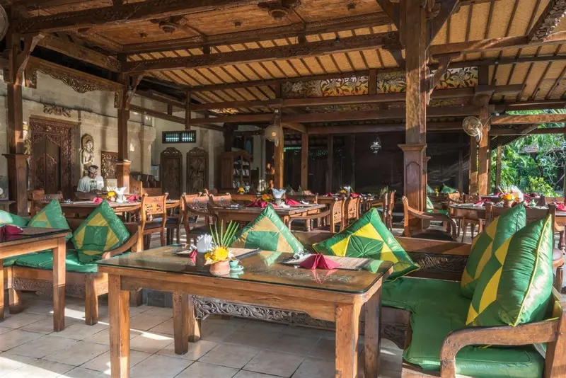 Une salle à manger extérieure avec des tables et des chaises en bois.