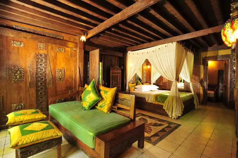 Une chambre à coucher avec un lit à baldaquin et un canapé vert.