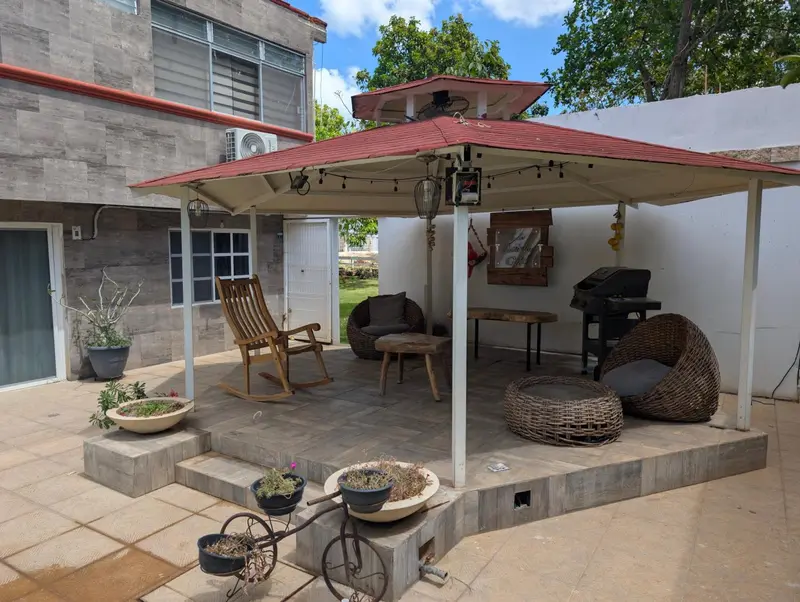 Espace extérieur aménagé avec des meubles de jardin et un parasol.