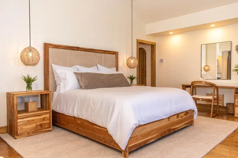 Une chambre lumineuse avec un grand lit recouvert de draps blancs.