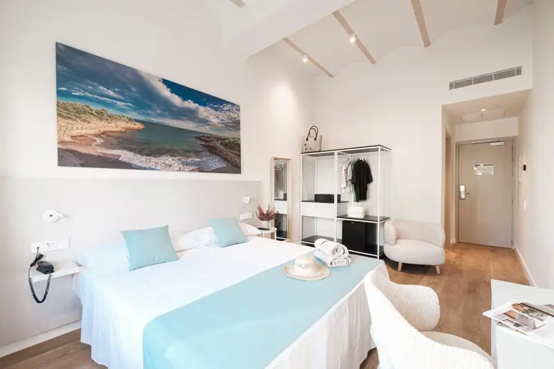 Chambre lumineuse avec un grand lit et une décoration moderne.
