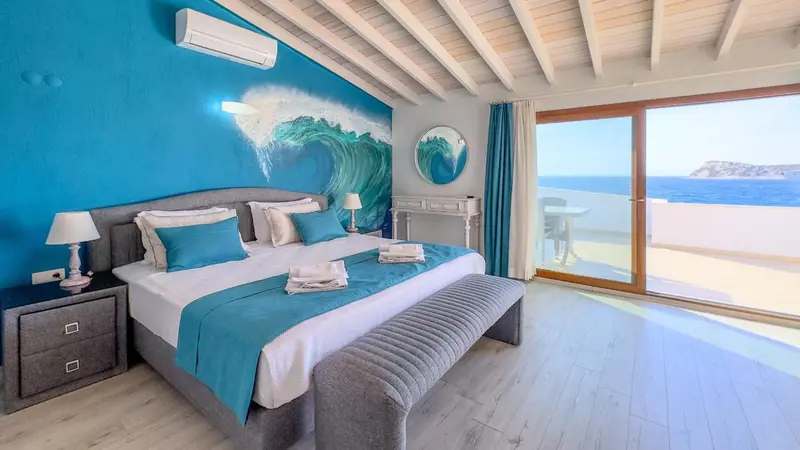 Une chambre lumineuse avec un grand lit et une vue sur la mer.