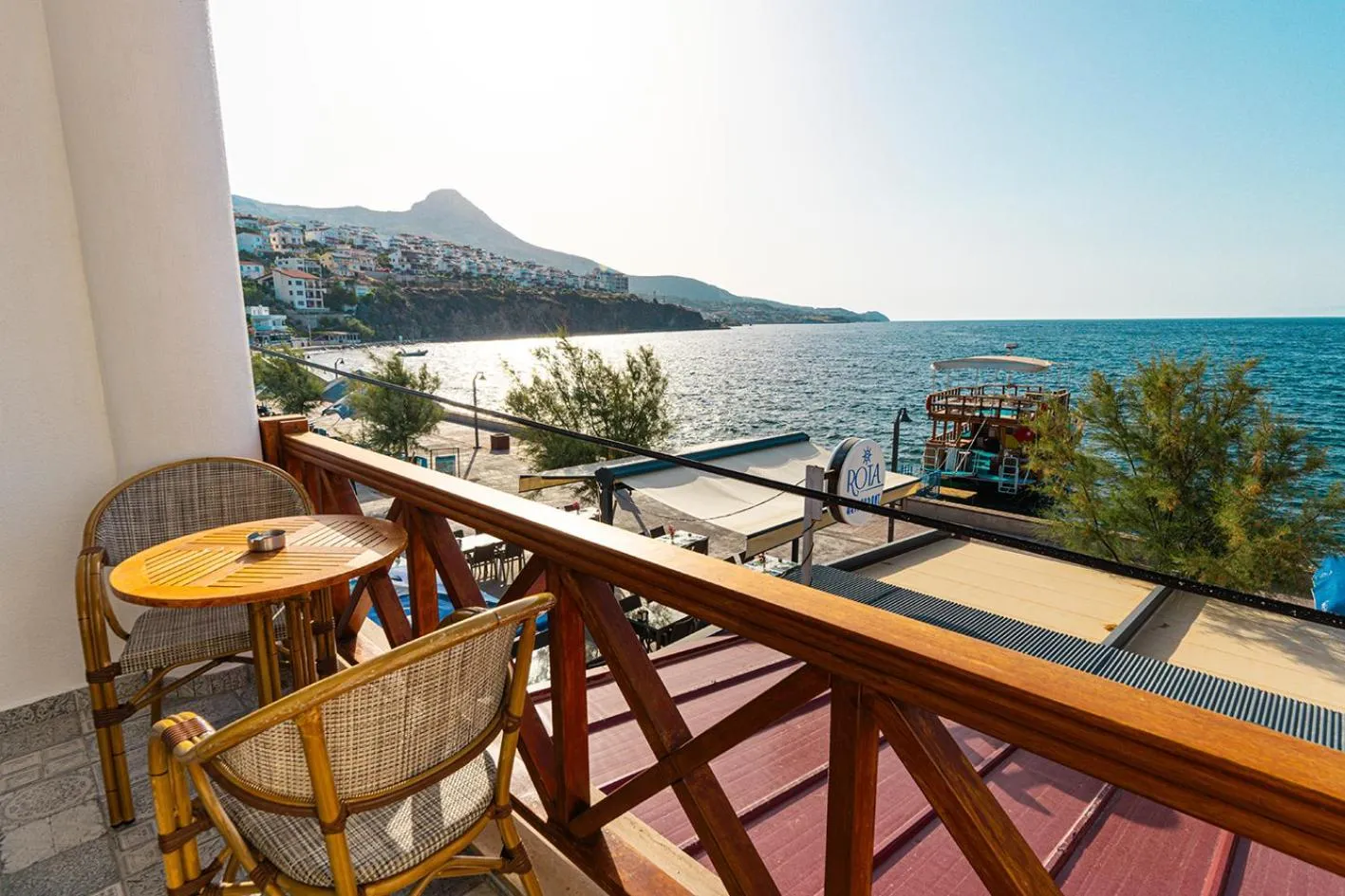 Terrasse avec mobilier en osier donnant sur la mer et les montagnes.