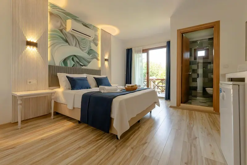 Une chambre lumineuse avec un grand lit et un accès à une terrasse.
