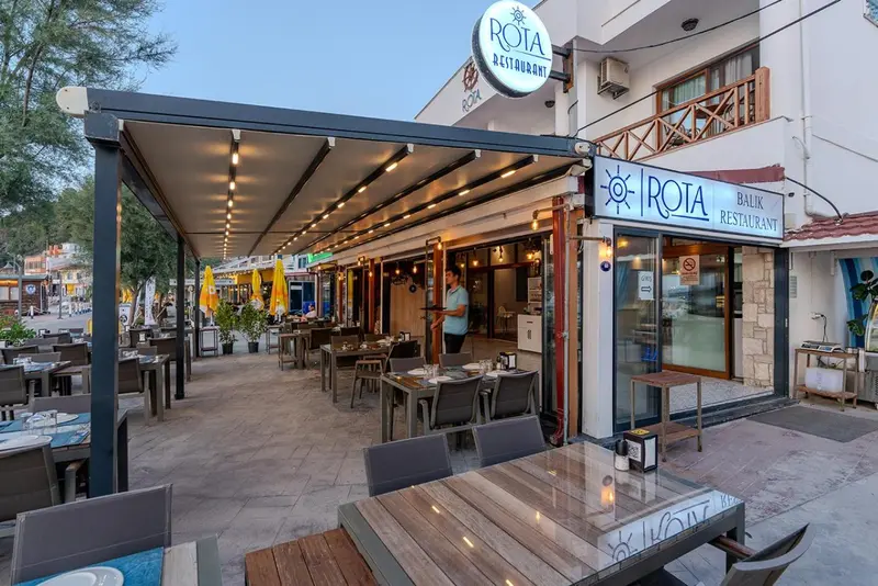 Terrasse de restaurant avec tables et chaises en extérieur.