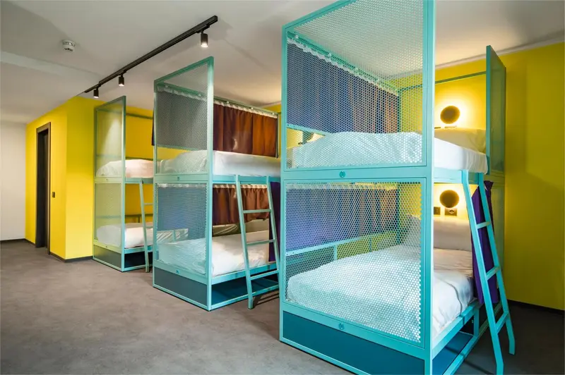 Lits superposés dans une chambre aux murs jaunes et verts.