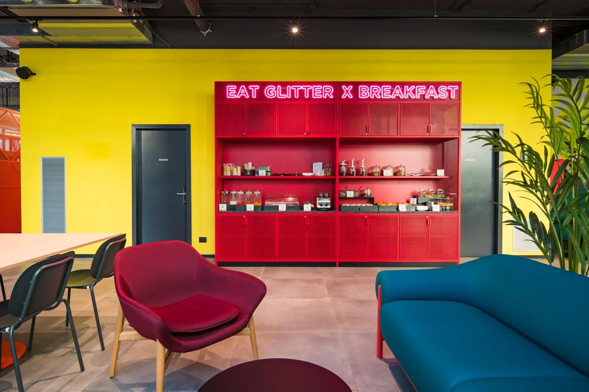 Espace de détente coloré avec des sièges confortables et une étagère décorative.