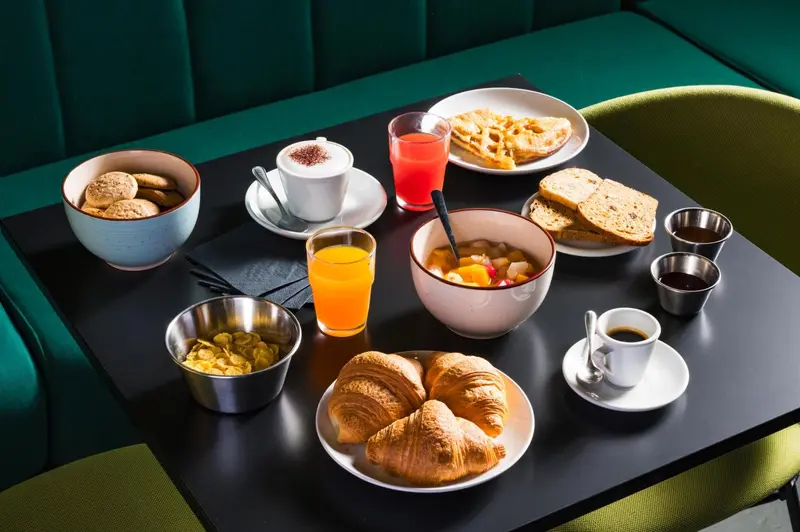 Une table est dressée avec un petit-déjeuner copieux.