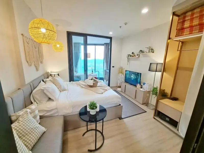 Une chambre lumineuse avec un grand lit et un accès à une terrasse.