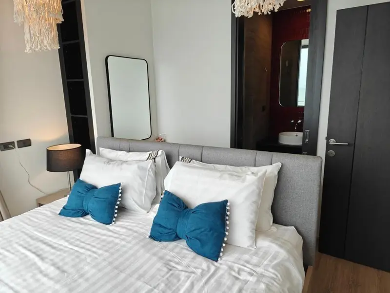 Une chambre lumineuse avec un grand lit recouvert de coussins bleus.
