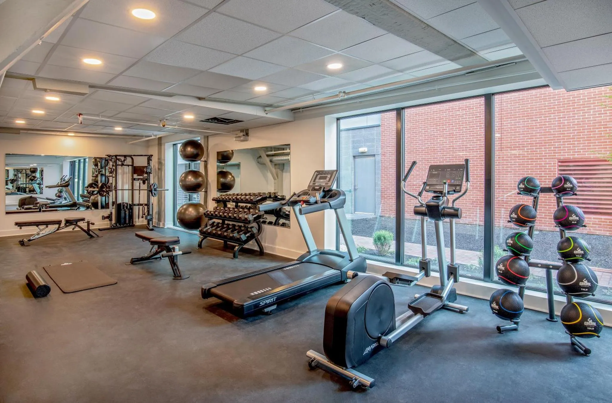 Une salle de sport lumineuse avec des équipements de musculation et cardiovasculaire.