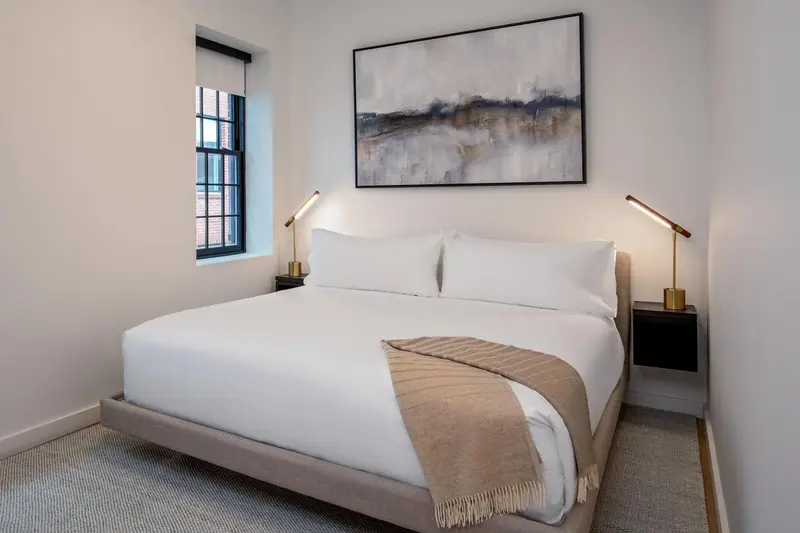 Une chambre lumineuse avec un grand lit et une décoration sobre.