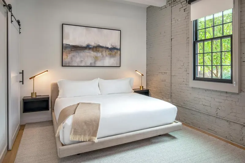 Une chambre lumineuse avec un grand lit et une décoration sobre.