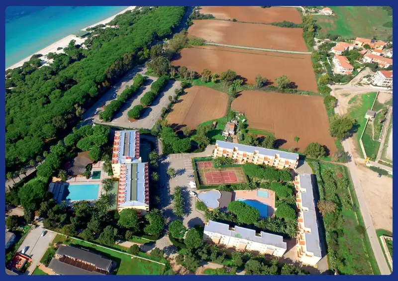 Vue aérienne d'un complexe hôtelier bordant une plage de sable fin.