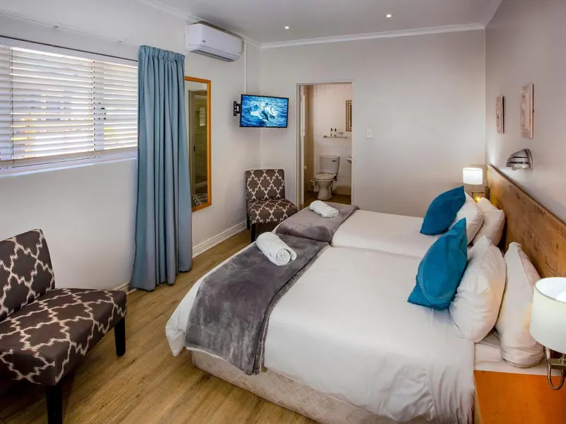 Une chambre lumineuse avec un lit double et un coin salon.