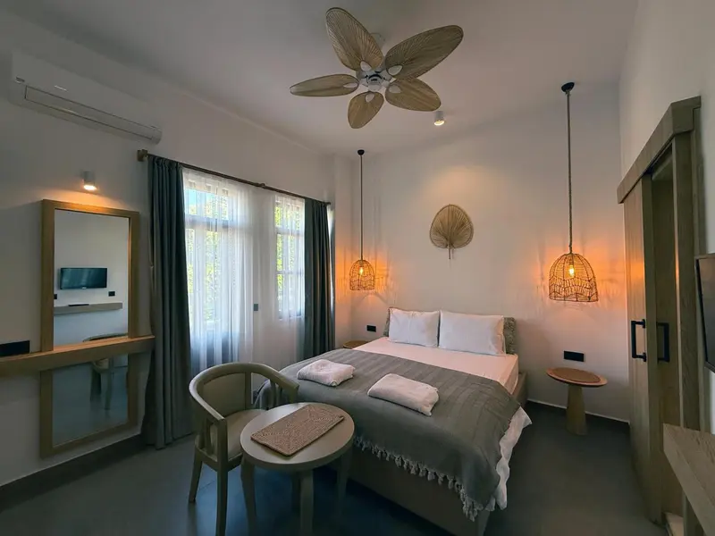 Une chambre lumineuse avec un lit double et un coin salon.