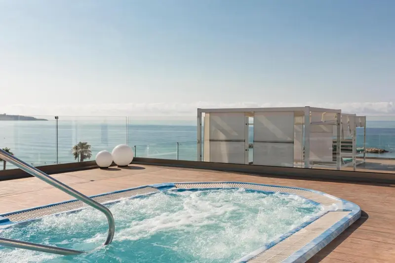 Un jacuzzi sur une terrasse avec vue sur la mer.