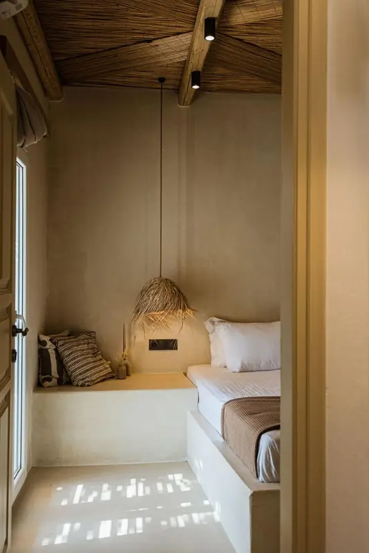 Une chambre lumineuse avec un lit simple et un coin lecture intégré dans un renfoncement mural.