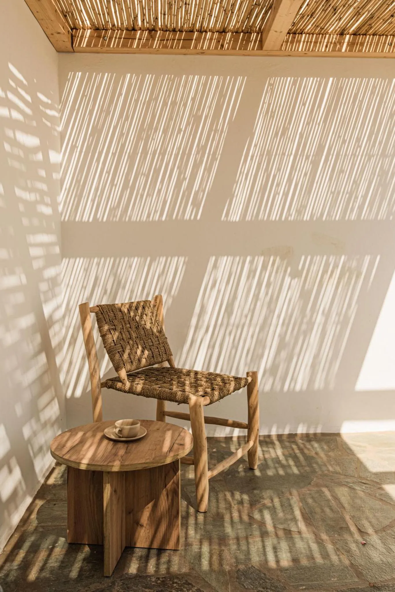 Un espace de détente intérieur avec une chaise en rotin et une petite table.