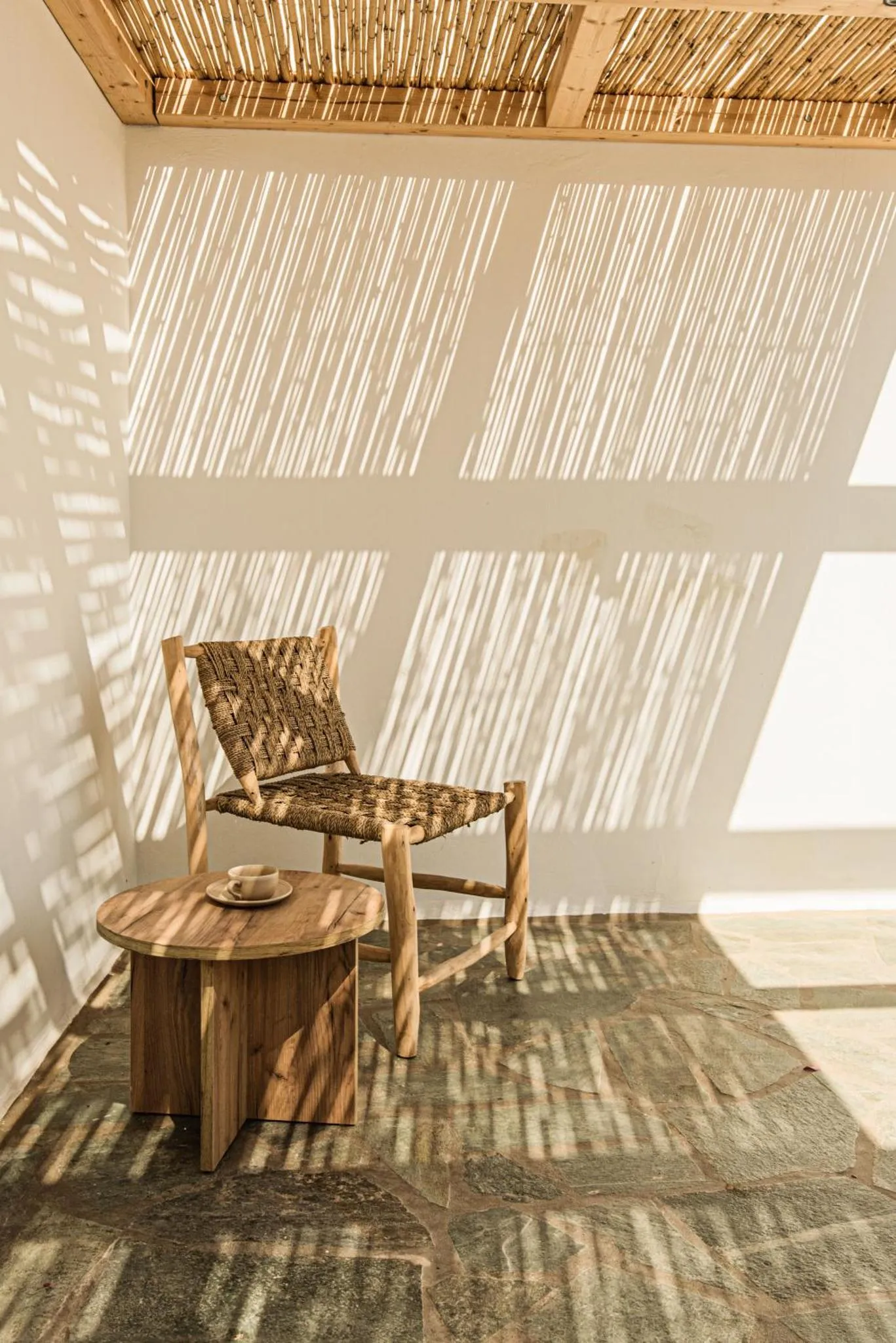 Un espace de détente extérieur avec une chaise en bois et une petite table.