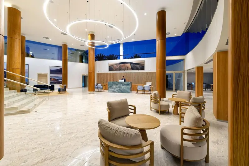 Vaste hall d'accueil avec comptoir de réception et assises confortables.