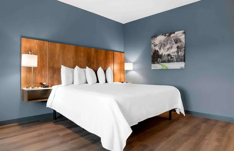 Une chambre d'hôtel avec un grand lit recouvert de linge blanc.