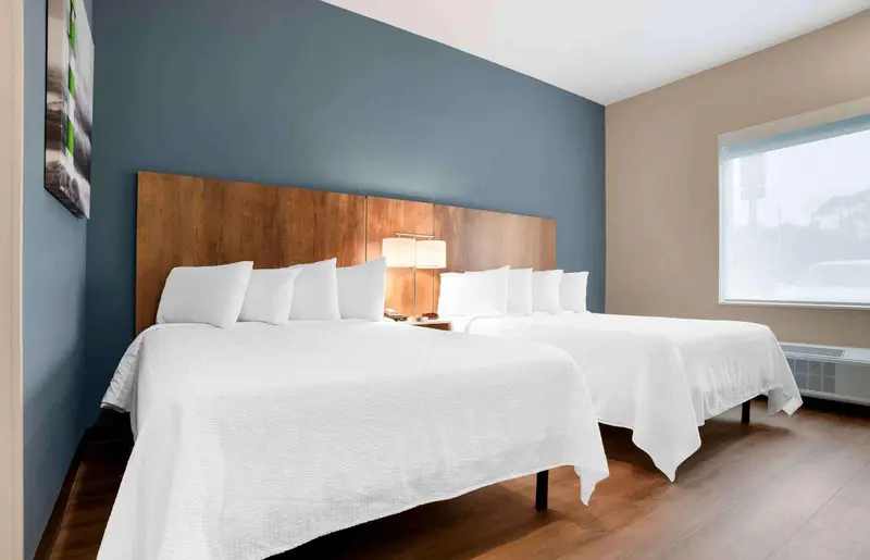 Une chambre d'hôtel avec deux lits doubles et une fenêtre.