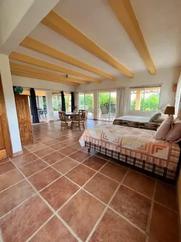 Une chambre lumineuse avec un grand lit et un coin repas.