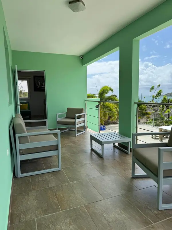 Terrasse aménagée avec mobilier d'extérieur et vue sur la végétation.