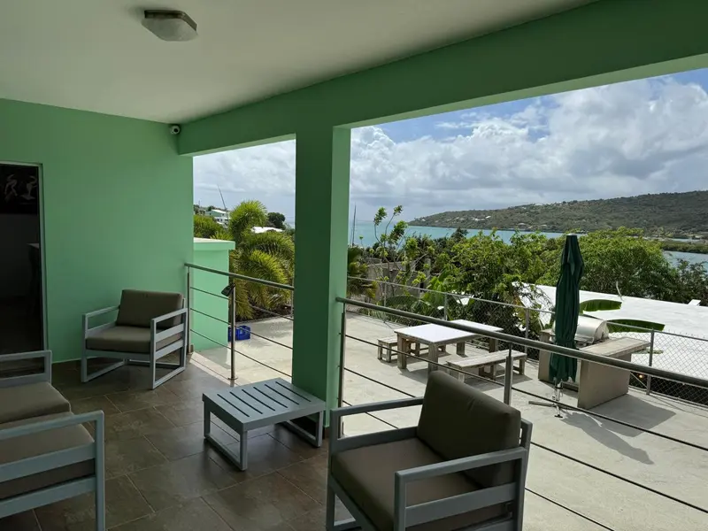 Espace extérieur aménagé avec des fauteuils et une vue sur la mer.