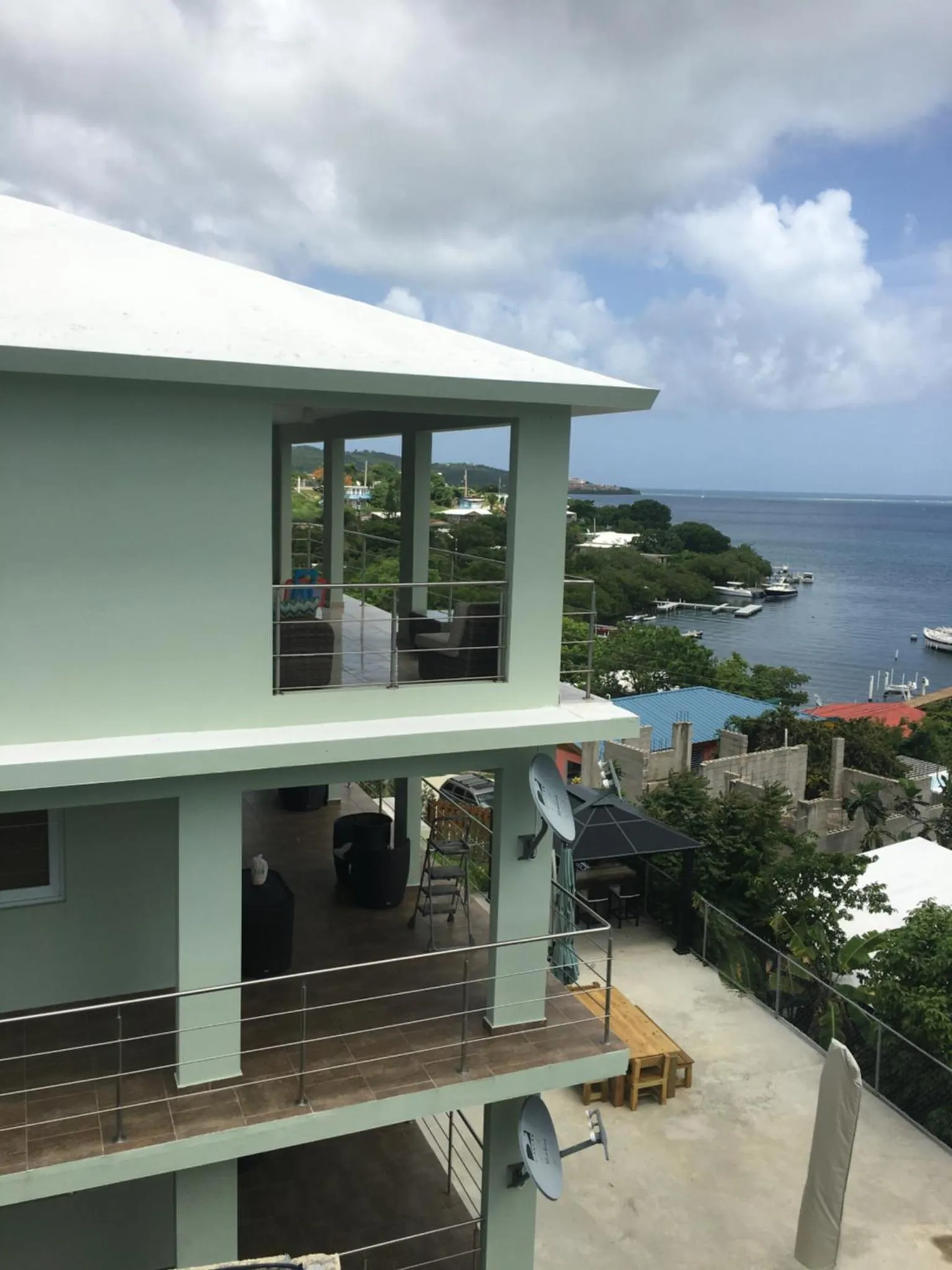 Vue d'une terrasse surélevée avec une vue sur la mer et la végétation.
