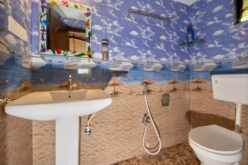 Une salle de bain avec un lavabo et des toilettes décorées de motifs marins.