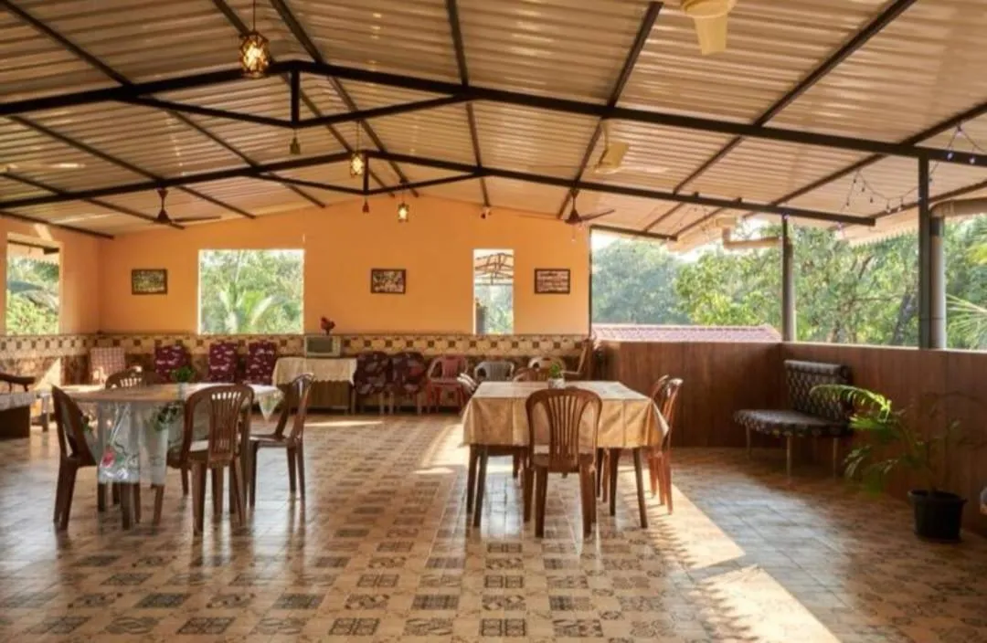 Une salle à manger extérieure avec des tables nappées et des chaises.