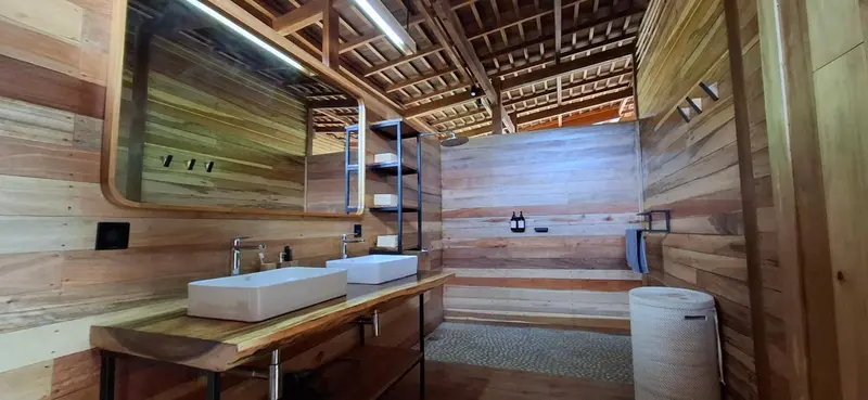 Salle de bain moderne avec deux vasques en bois et douche à l'italienne.