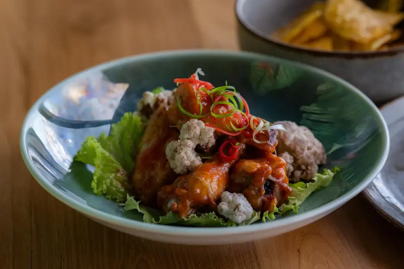 Assiette de poulet frit épicé servi avec de la salade et des chips.