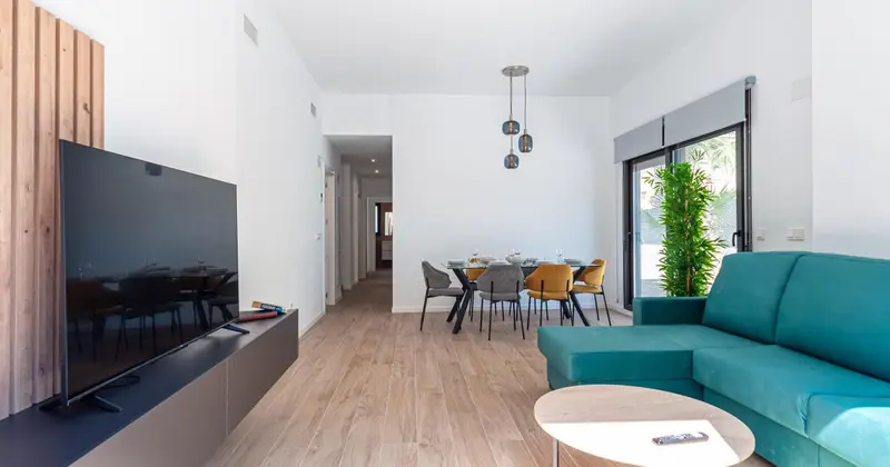 Un salon moderne s'ouvre sur une salle à manger lumineuse.